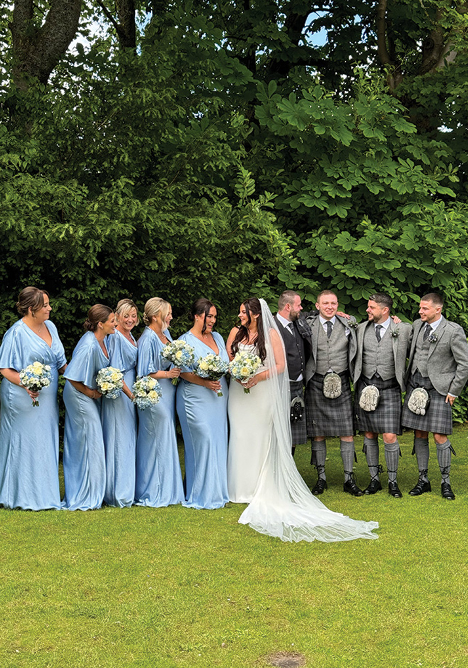 Bride and groom standing with groomsmen and bridal party